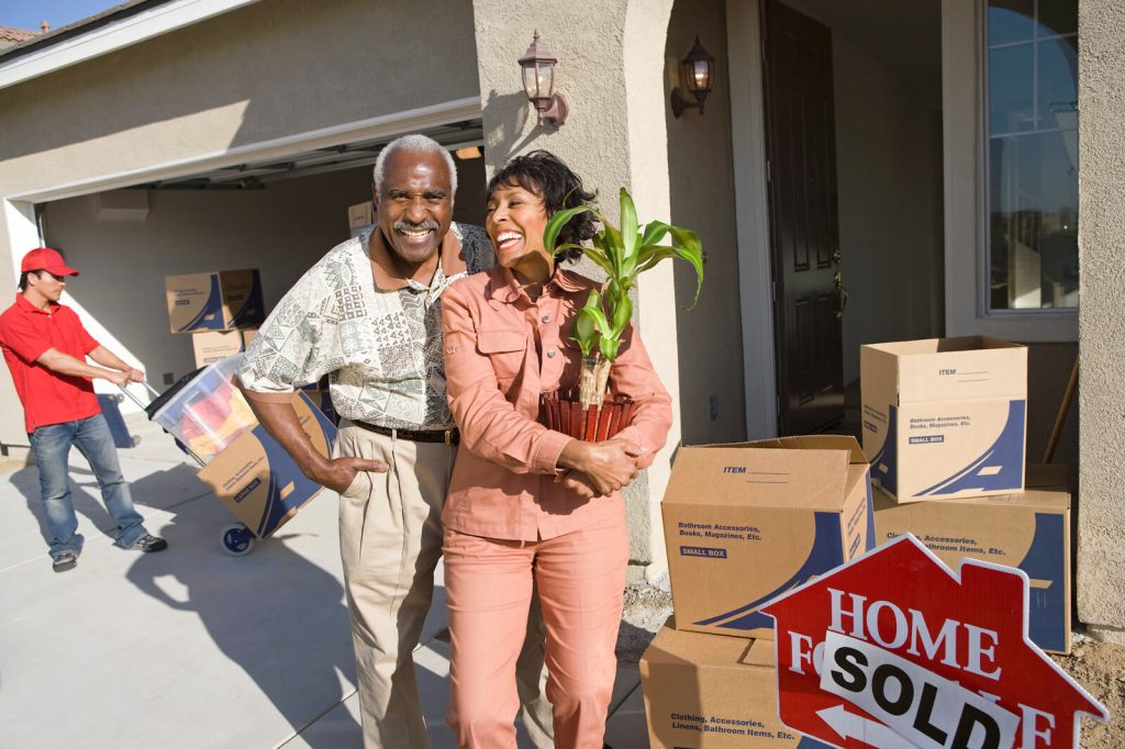 Happy seniors moving day selling home.