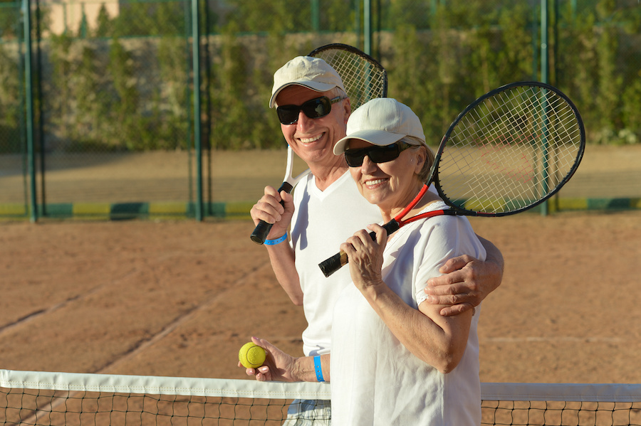 senior couple playing tennis outdoors